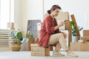 woman moving house checking phone